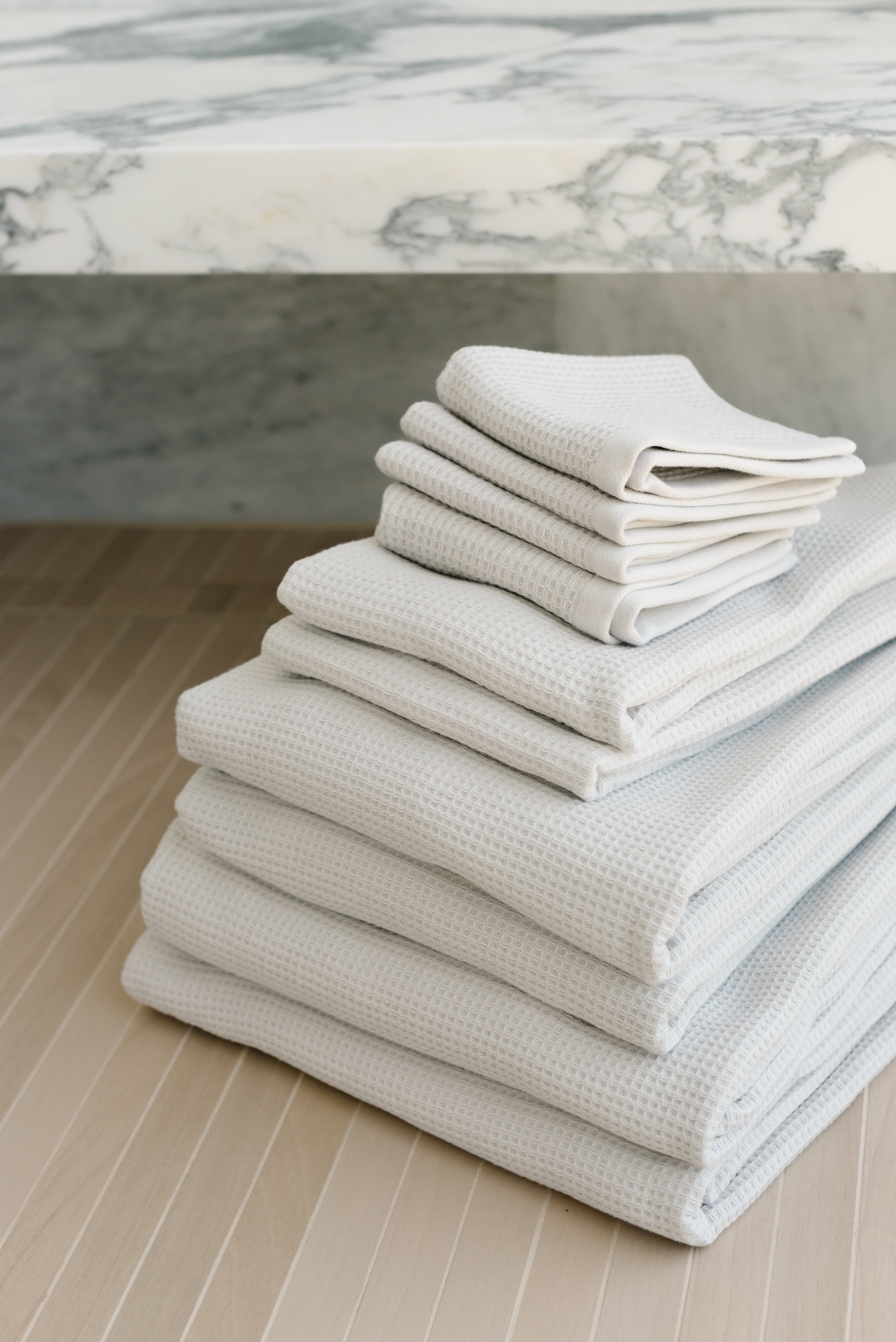 Complete Waffle Bath Bundle in the color Light Grey. Photo of Light Grey Complete Waffle Bath Bundle taken resting on floor of bathroom. 