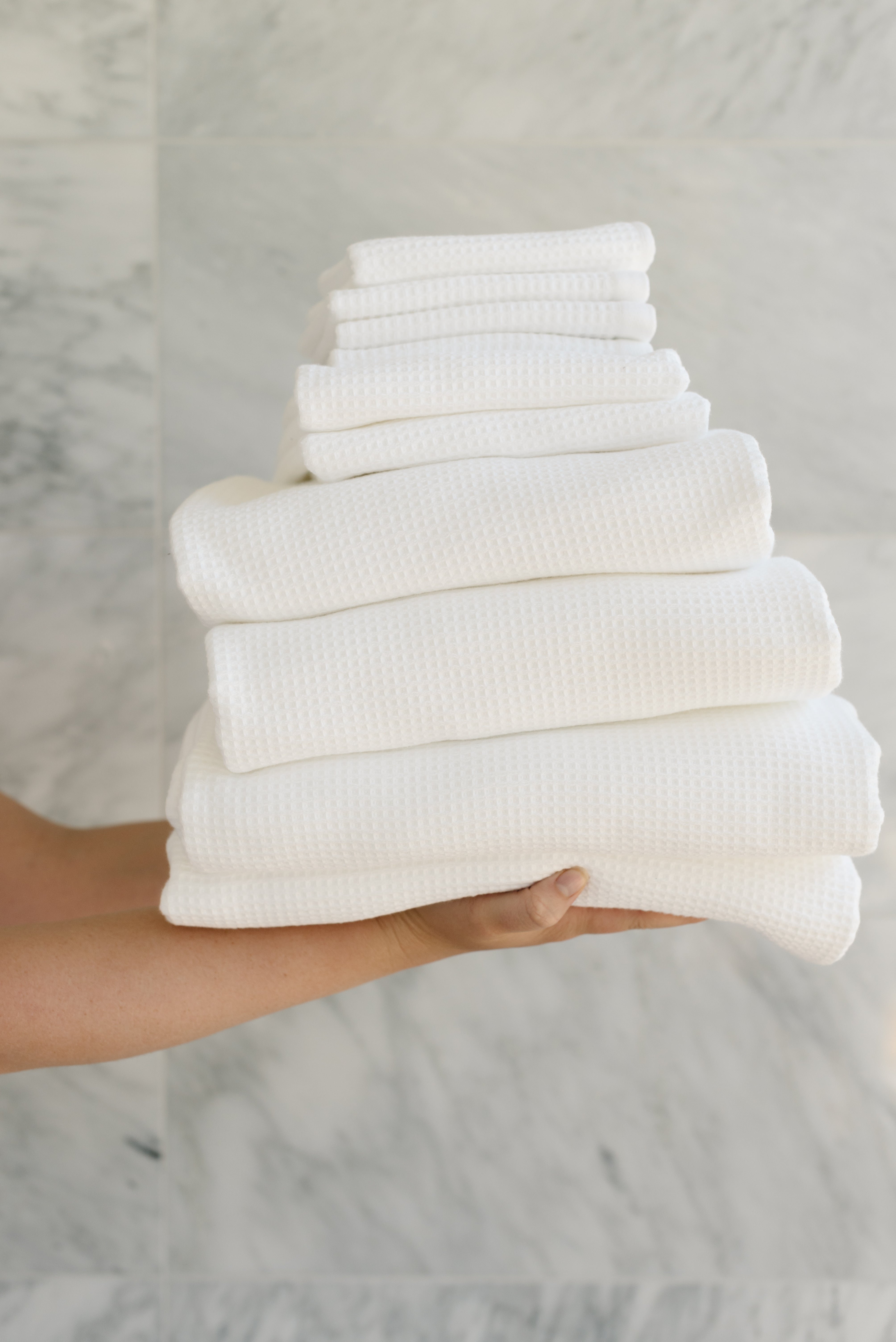 Complete Waffle Bath Bundle in the color White. Photo of White Complete Waffle Bath Bundle taken while being held by a persons outreached hands 