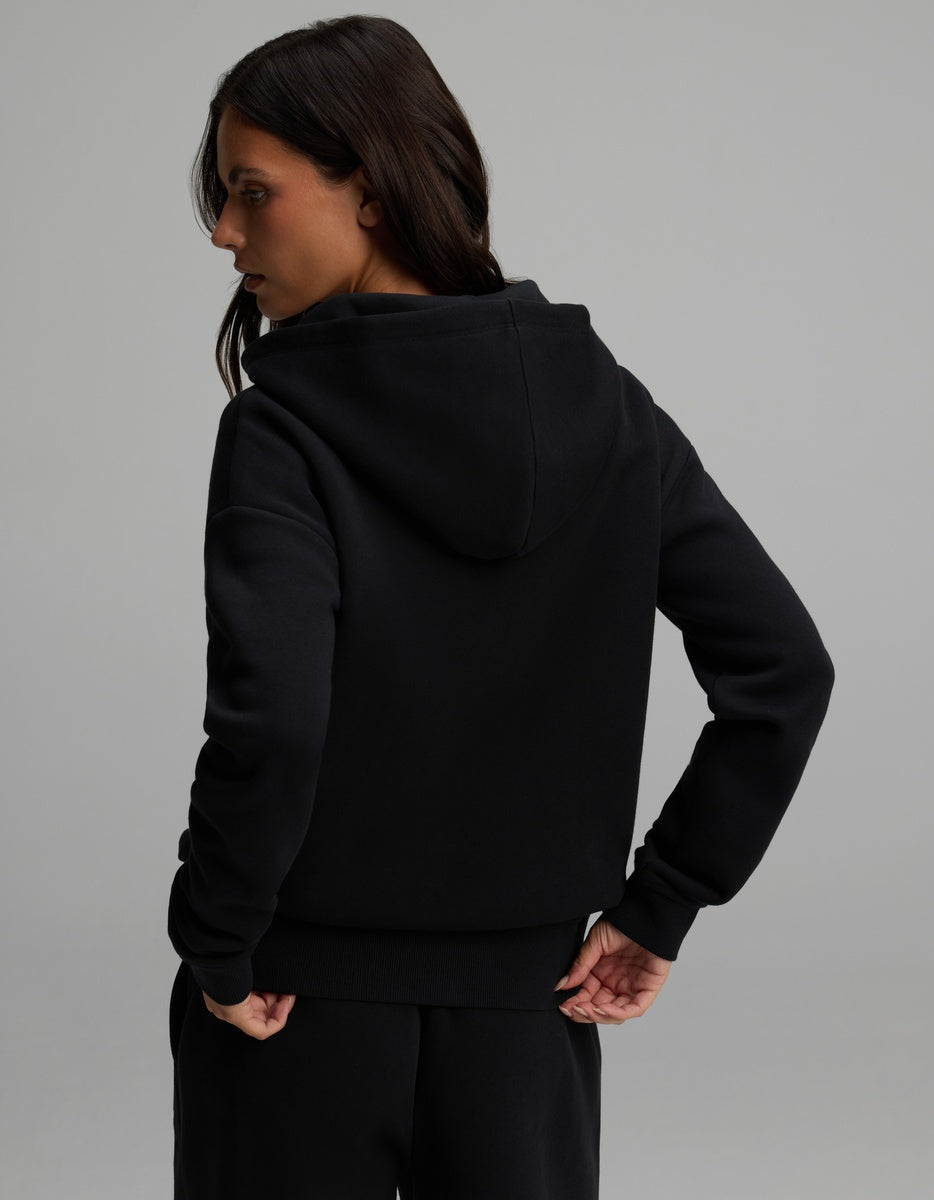 A woman seen from the back wearing a black long-sleeved Women’s CityScape Full-Zip Hoodie.