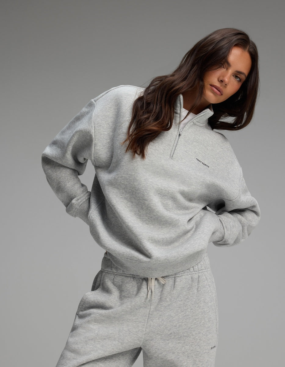 A person wearing a grey Women’s CityScape Quarter Zip and matching joggers.