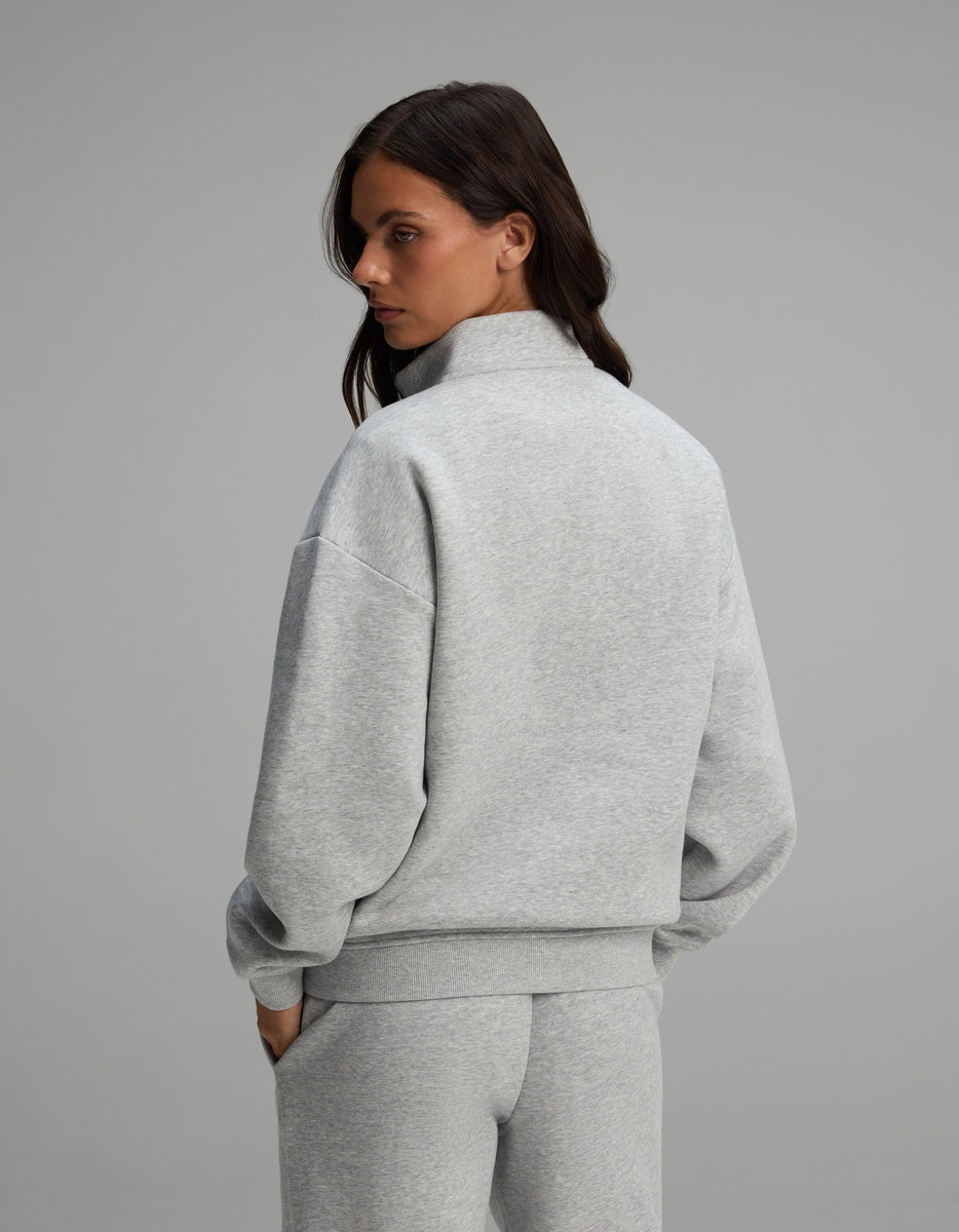 A person seen from behind wearing a light gray Cozy Earth Women’s CityScape Quarter Zip and matching sweatpants.