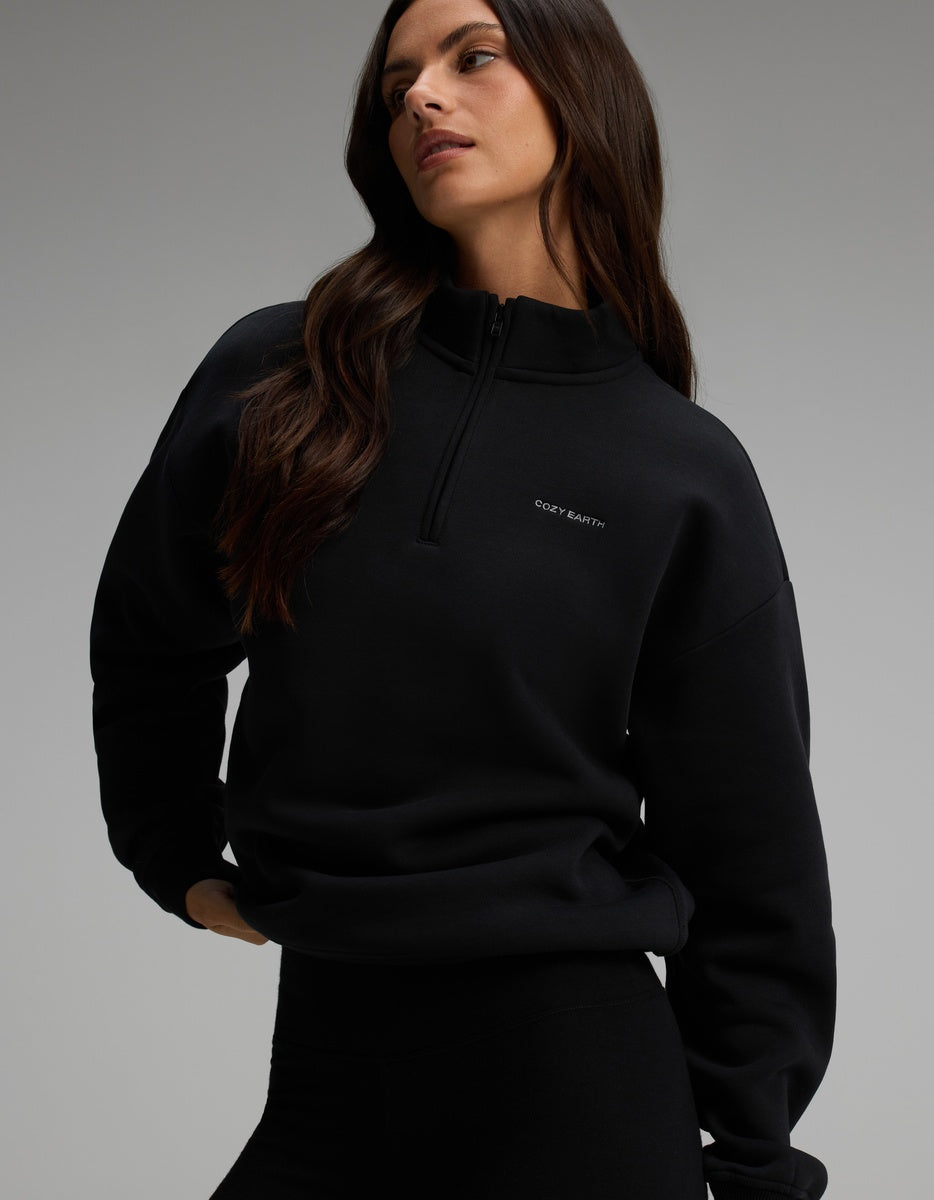 A woman wearing a black long-sleeve Cozy Earth Women’s CityScape Quarter Zip.