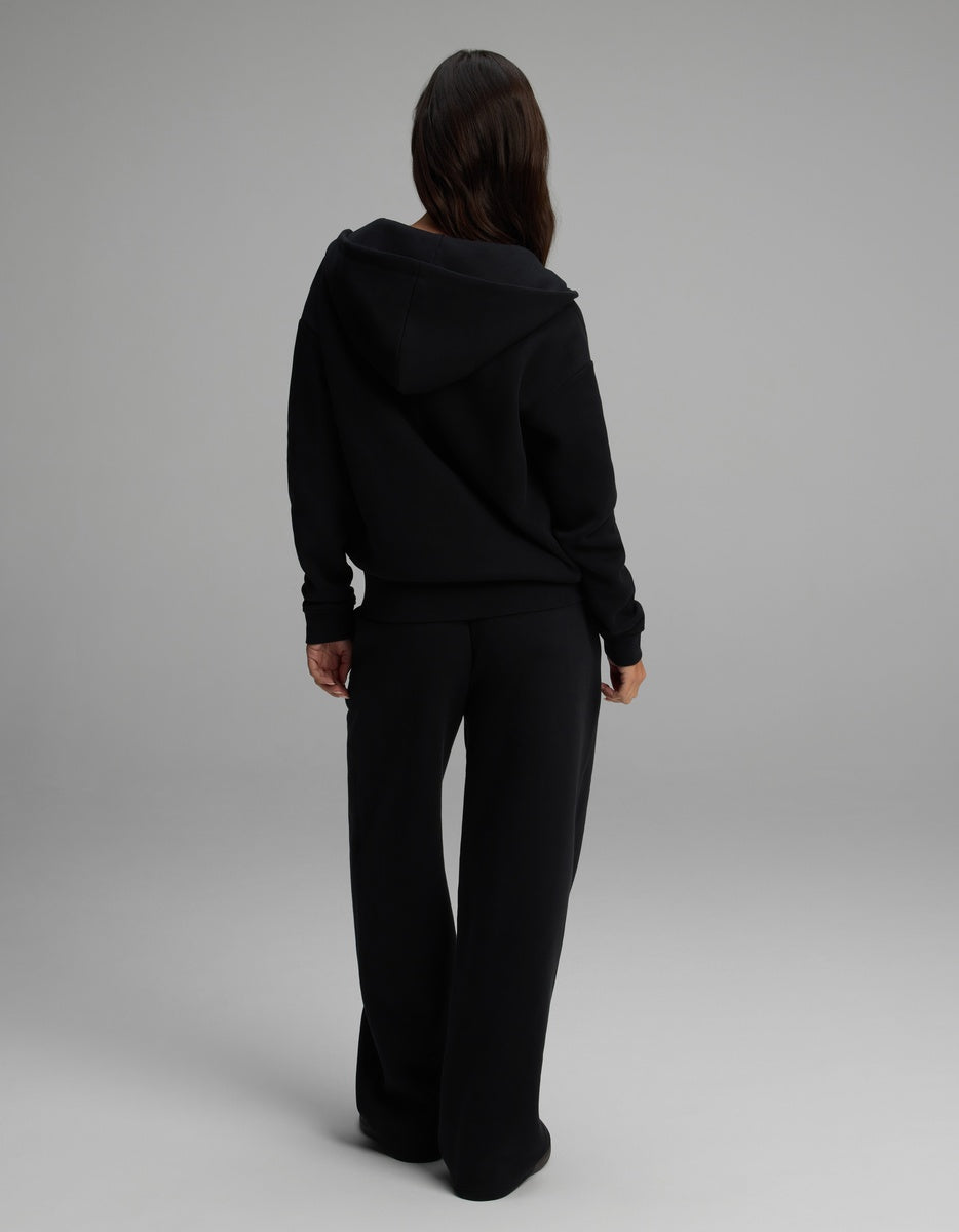 Back view of a person wearing a black Women’s Cityscape Full-Zip Hoodie & Wide Leg Pant Set with a full-zip hoodie and matching wide-leg pants.