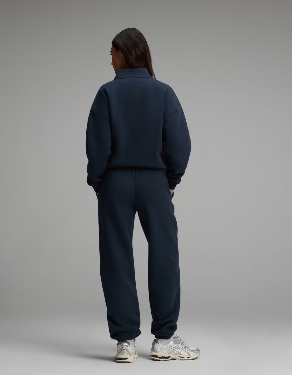 A person seen from behind wearing a dark blue Cozy Earth Women’s Cityscape Quarter Zip & Sweatpant Set with silver sneakers.
