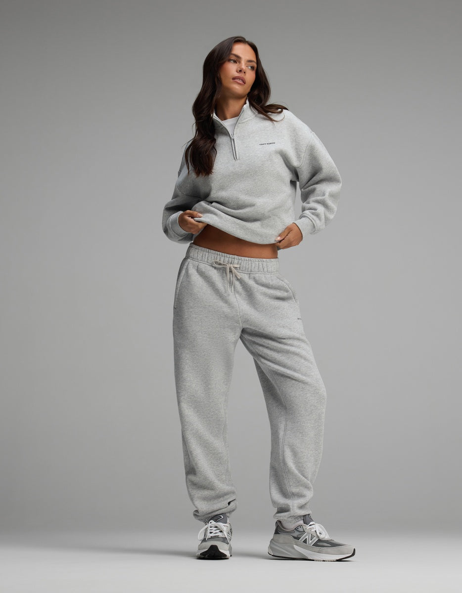 A woman wearing a light gray Cozy Earth Women’s Cityscape Quarter Zip & Sweatpant Set with sneakers.