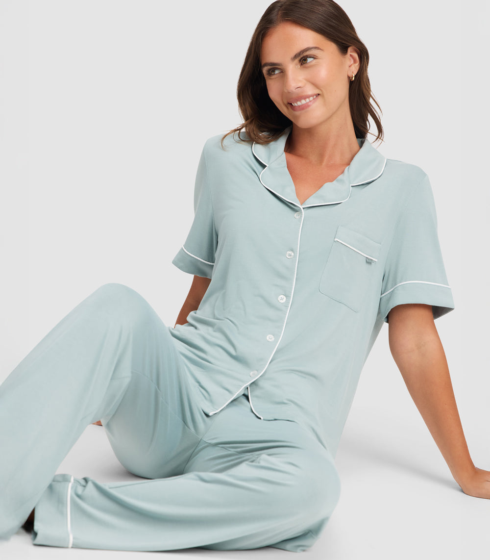 A woman sits on the floor wearing Cozy Earth Stretch Knit Bamboo Pajama Set in Brook