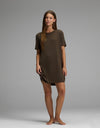 A woman stands barefoot on a plain backdrop, wearing the Cozy Earth Women’s Bamboo Rib-Knit Boyfriend Sleep Dress in brown. She faces forward with a relaxed posture and a neutral expression.|Color:Espresso