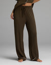 A person is shown from the waist down, standing barefoot on a gray background, wearing Cozy Earth’s Women’s Bamboo Rib-Knit Classic Pajama Pant in brown with a comfortable drawstring waist.|Color:Espresso