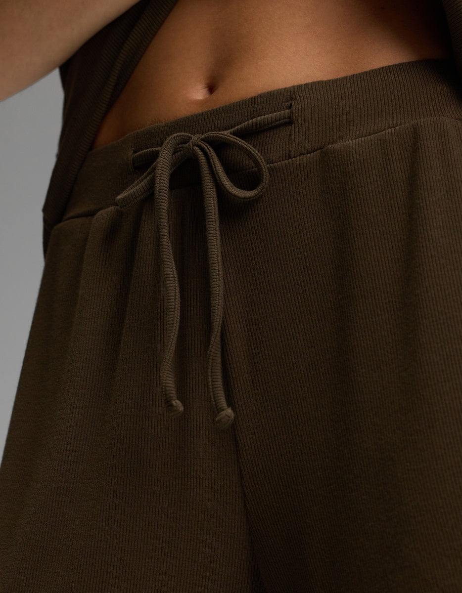 Close-up of a person wearing Cozy Earth’s Women’s Bamboo Rib-Knit Classic Pajama Short in brown. The tied drawstring and ribbed waistband are visible, along with part of the lower torso and abdomen.