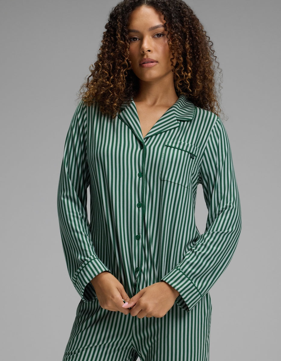 A person wearing a Cozy Earth Women’s Bamboo Stretch-Knit Long Sleeve Pajama Top, featuring a green and white vertical stripe pattern, notch collar, and long sleeves.
