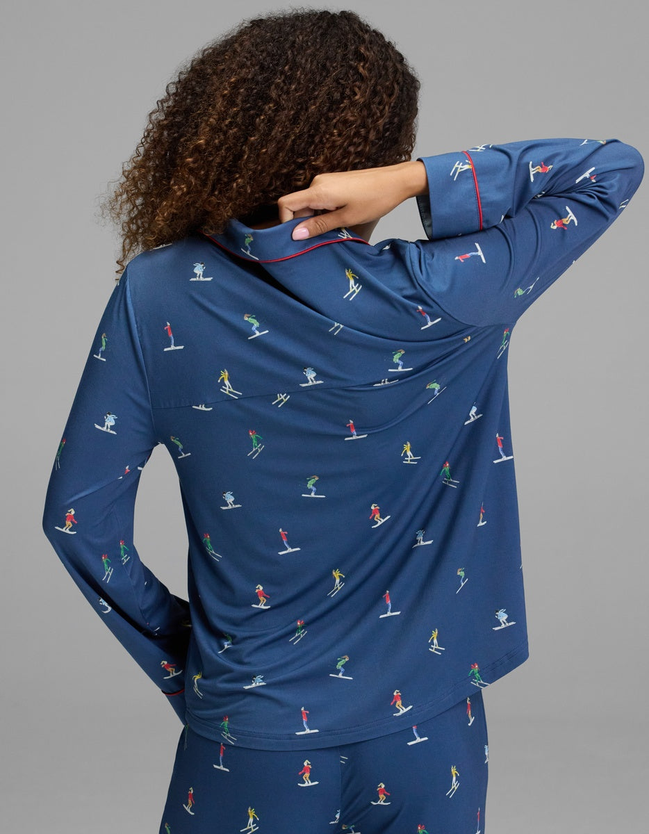 Cozy Earth Women’s Bamboo Stretch-Knit Long Sleeve Pajama Top in blue with a colorful ski-themed print and red trim.