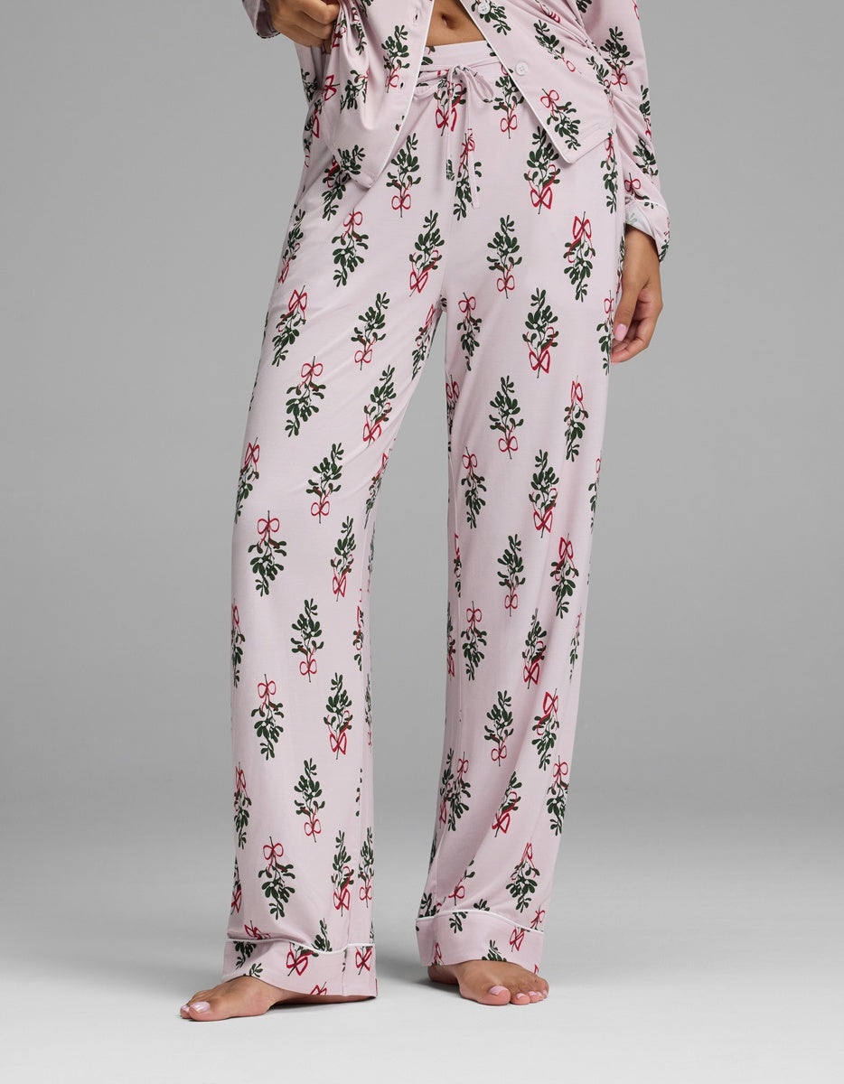 Cozy Earth Women’s Bamboo Stretch-Knit Pajama Pant in light pink with a repeating pattern of red bows and green holly leaves.