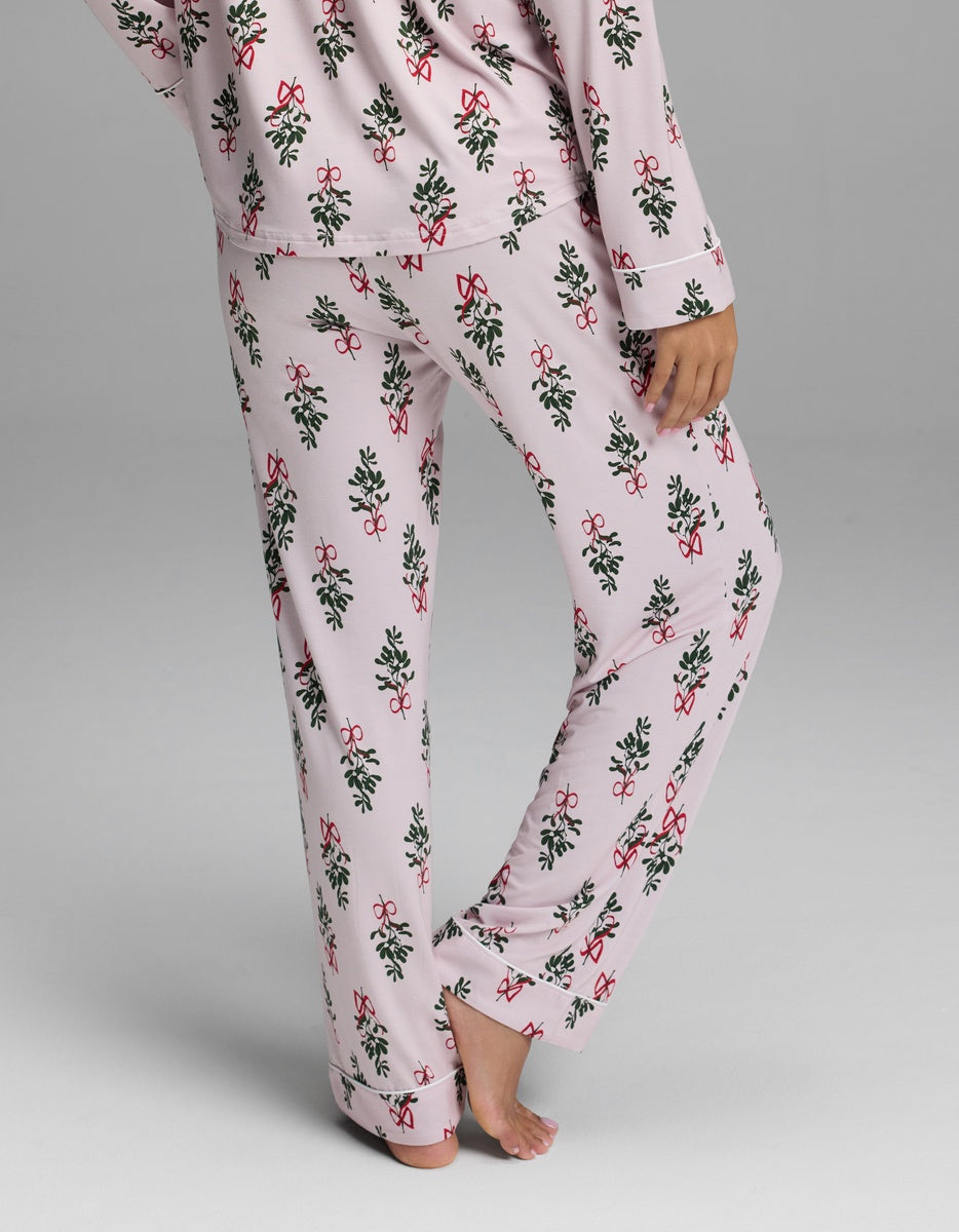 Cozy Earth Women’s Bamboo Stretch-Knit Pajama Pant in light pink with a repeating pattern of green holly leaves and red berries.