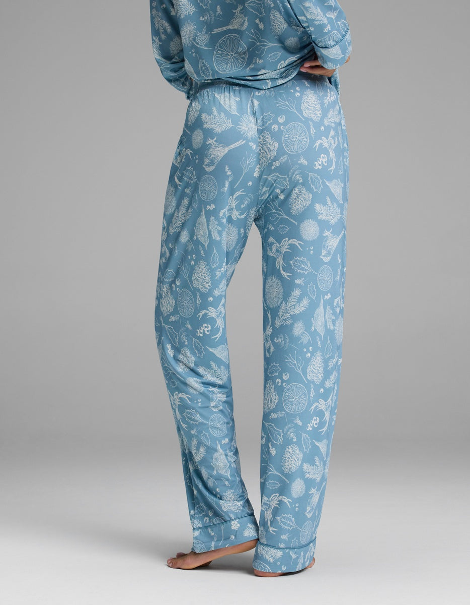 Cozy Earth Women’s Bamboo Stretch-Knit Pajama Pant in blue with a white pattern of pinecones, greenery, and citrus slices.