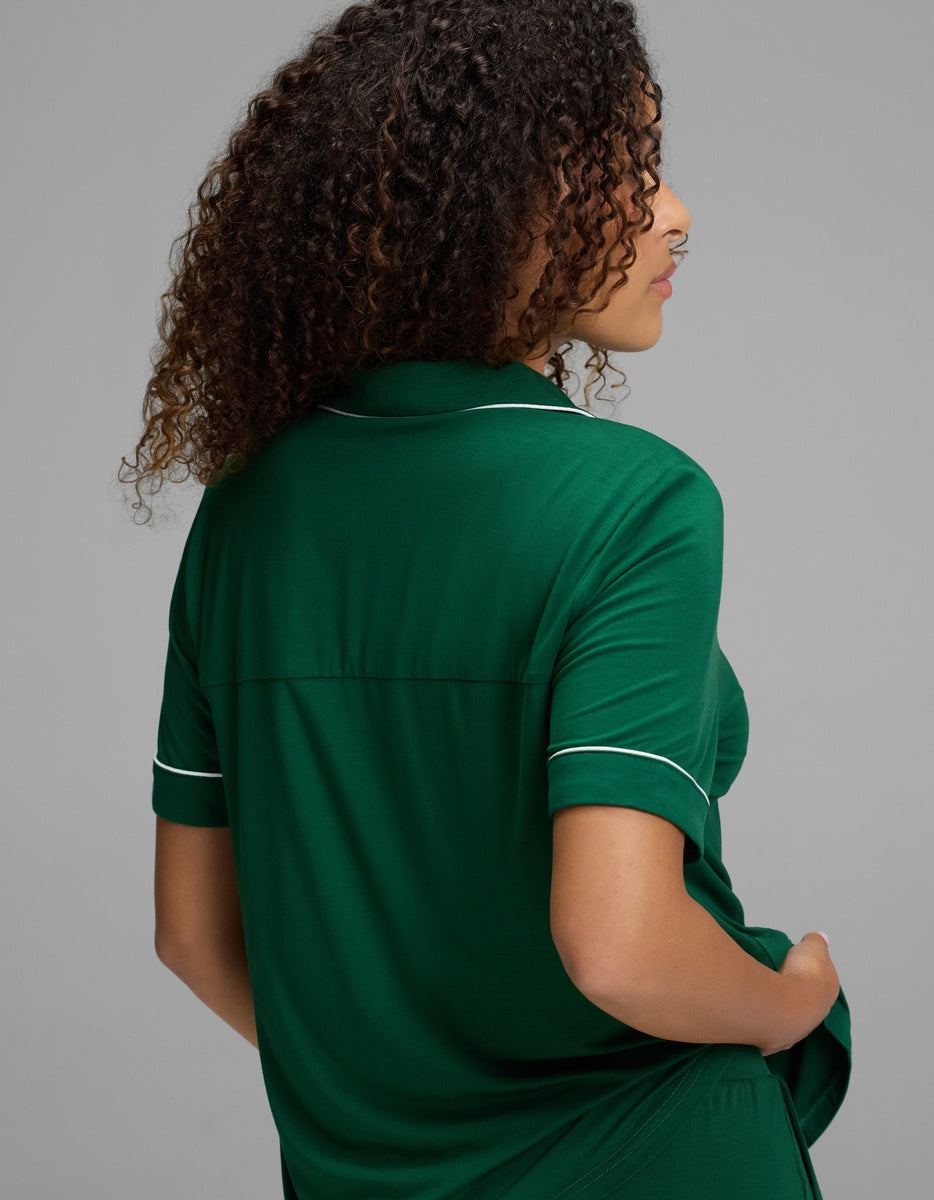 A Cozy Earth Women’s Bamboo Stretch-Knit Short Sleeve Pajama Top in green with white piping on the collar and sleeve cuffs.