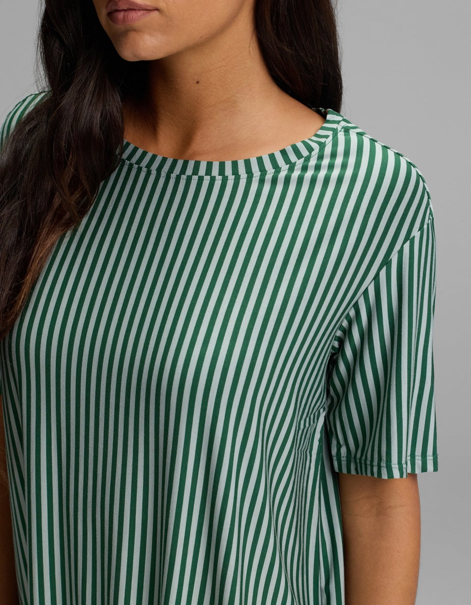 A person wearing a Cozy Earth Women’s Bamboo Stretch-Knit Sleep Dress, featuring short sleeves, a round neckline, and thin vertical green and white stripes.
