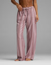 A person stands barefoot wearing Cozy Earth’s Women’s Belmont Pajama Pant, featuring a loose fit, pink color, vertical stripes, and a drawstring waist. The upper body is mostly out of frame.|Color:Viola Stripe
