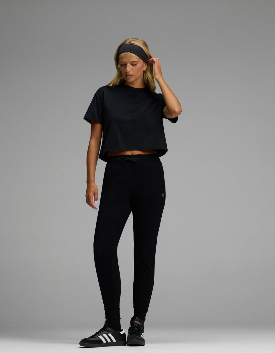 A woman wearing Cozy Earth’s Women’s Brushed Bamboo Jogger stands against a plain gray background.