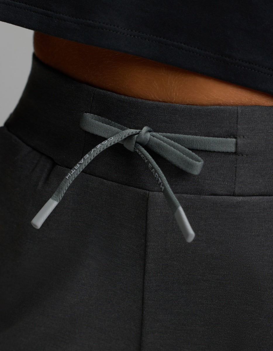 A close-up of the gray drawstring tied in a bow on the waistband of Cozy Earth’s Women’s Brushed Bamboo Jogger in dark gray, worn by a person in a black shirt.