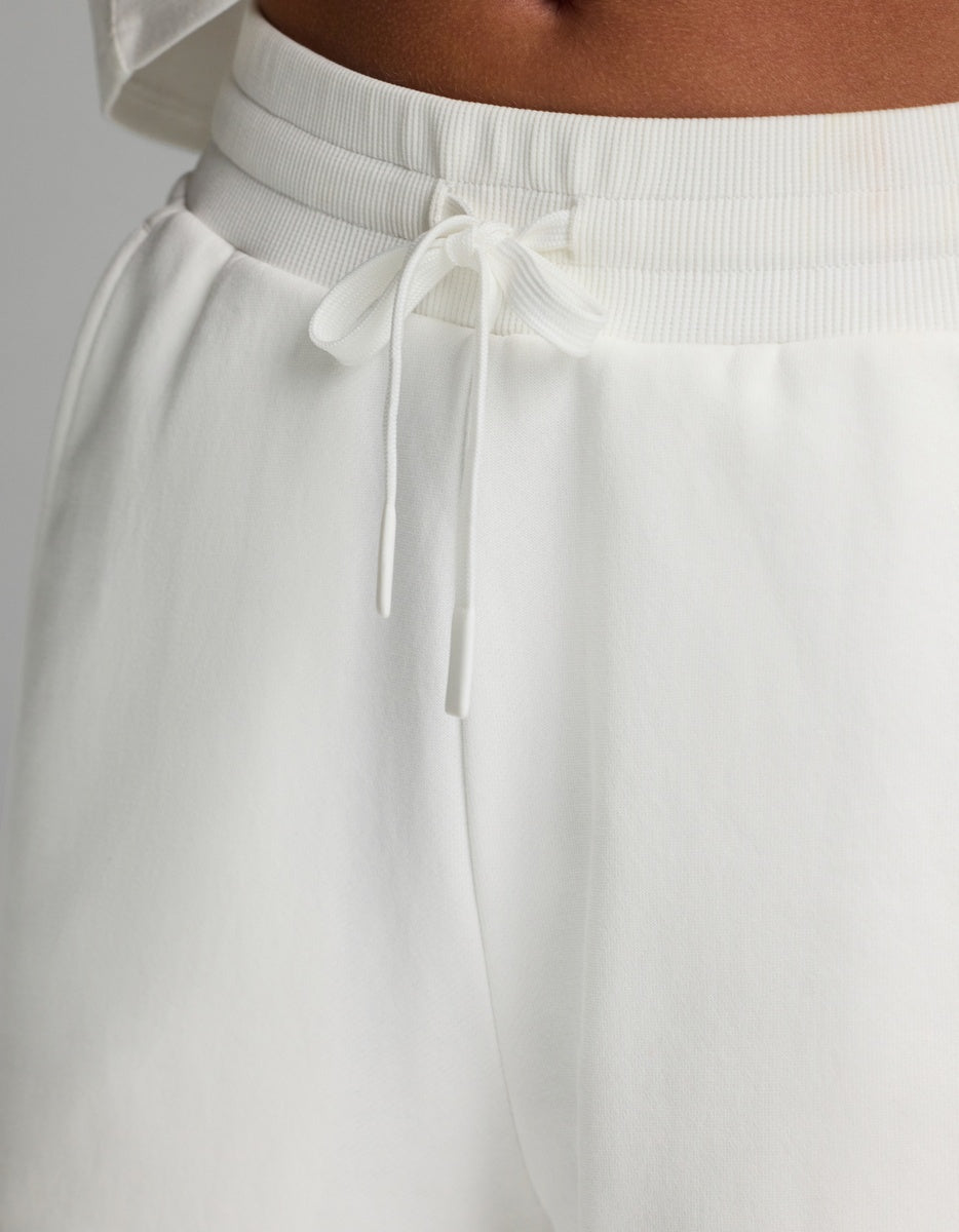Close-up of a person wearing the Cozy Earth Women’s Chelsea Pant in white, paired with a matching white top, highlighting the waistband and tied drawstring.