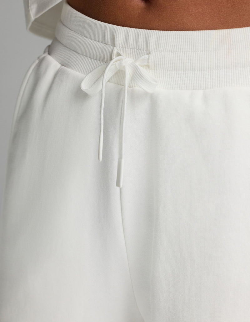Close-up of a person wearing the Cozy Earth Women’s Chelsea Pant in white, paired with a matching white top, highlighting the waistband and tied drawstring.