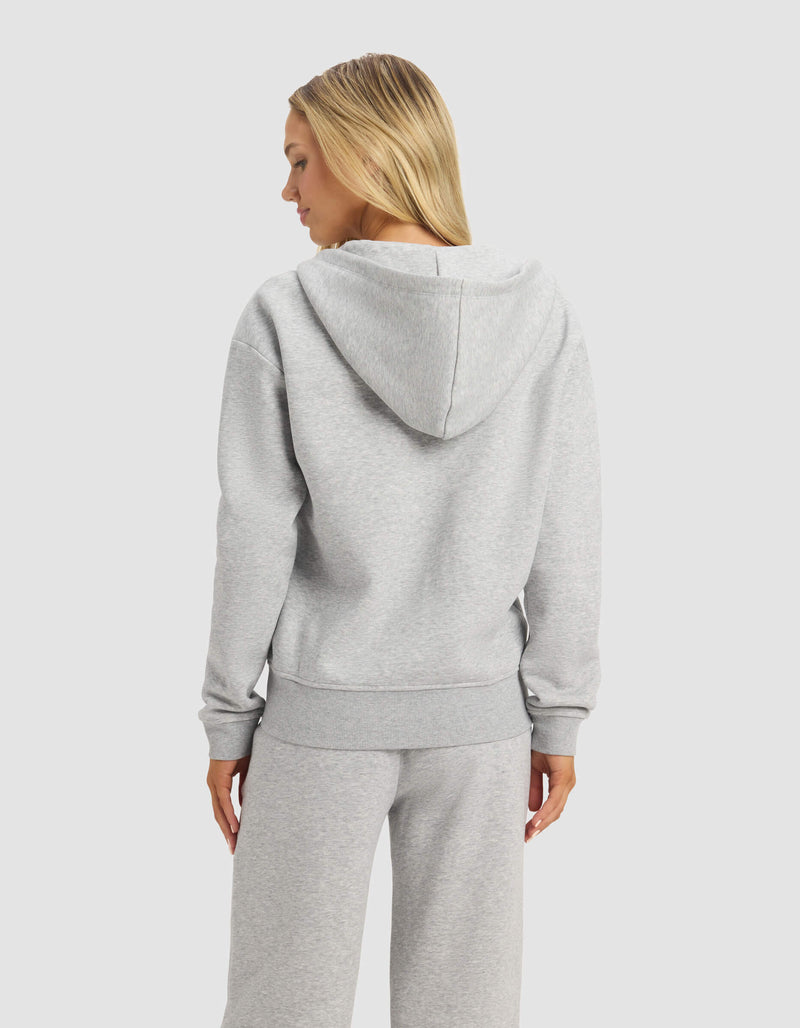 A woman with straight blonde hair is seen from behind, wearing the Cozy Earth Women's CityScape 2.0 Full Zip in light gray against a plain white background.