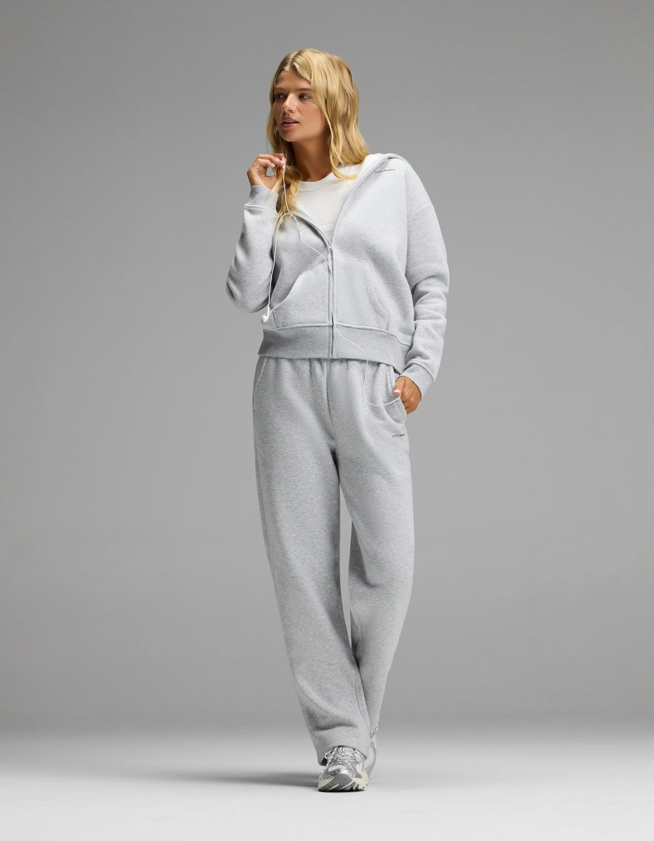 A person wearing a grey Women’s Cityscape Full-Zip Hoodie & Wide Leg Pant Set over a white t-shirt with athletic sneakers.