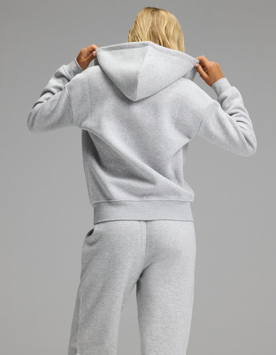 A person seen from behind wearing a light gray Women’s Cityscape Full-Zip Hoodie & Wide Leg Pant Set consisting of a hooded zip-up sweatshirt and matching wide-leg pants.