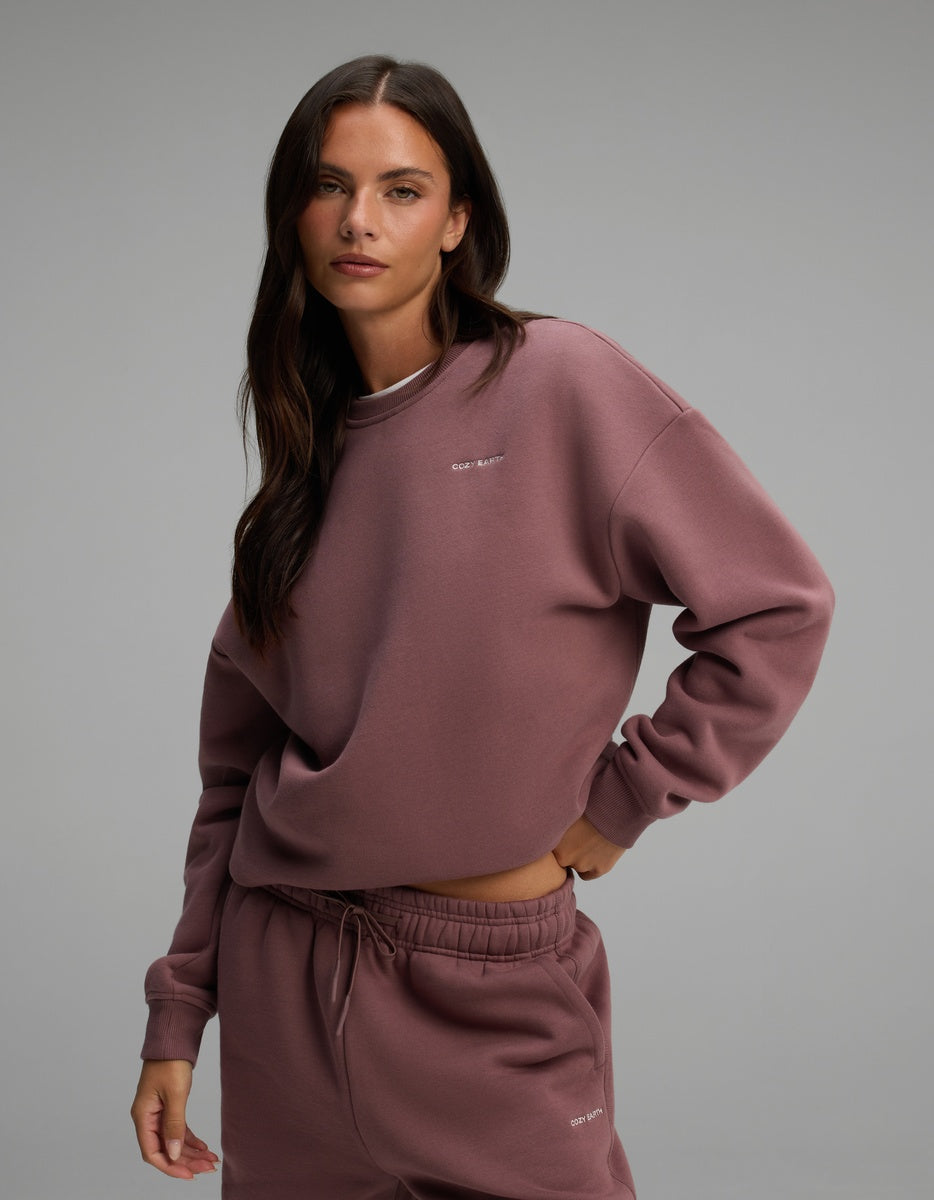 A woman wearing a mauve Women’s CityScape Crewneck and matching drawstring sweatpants.