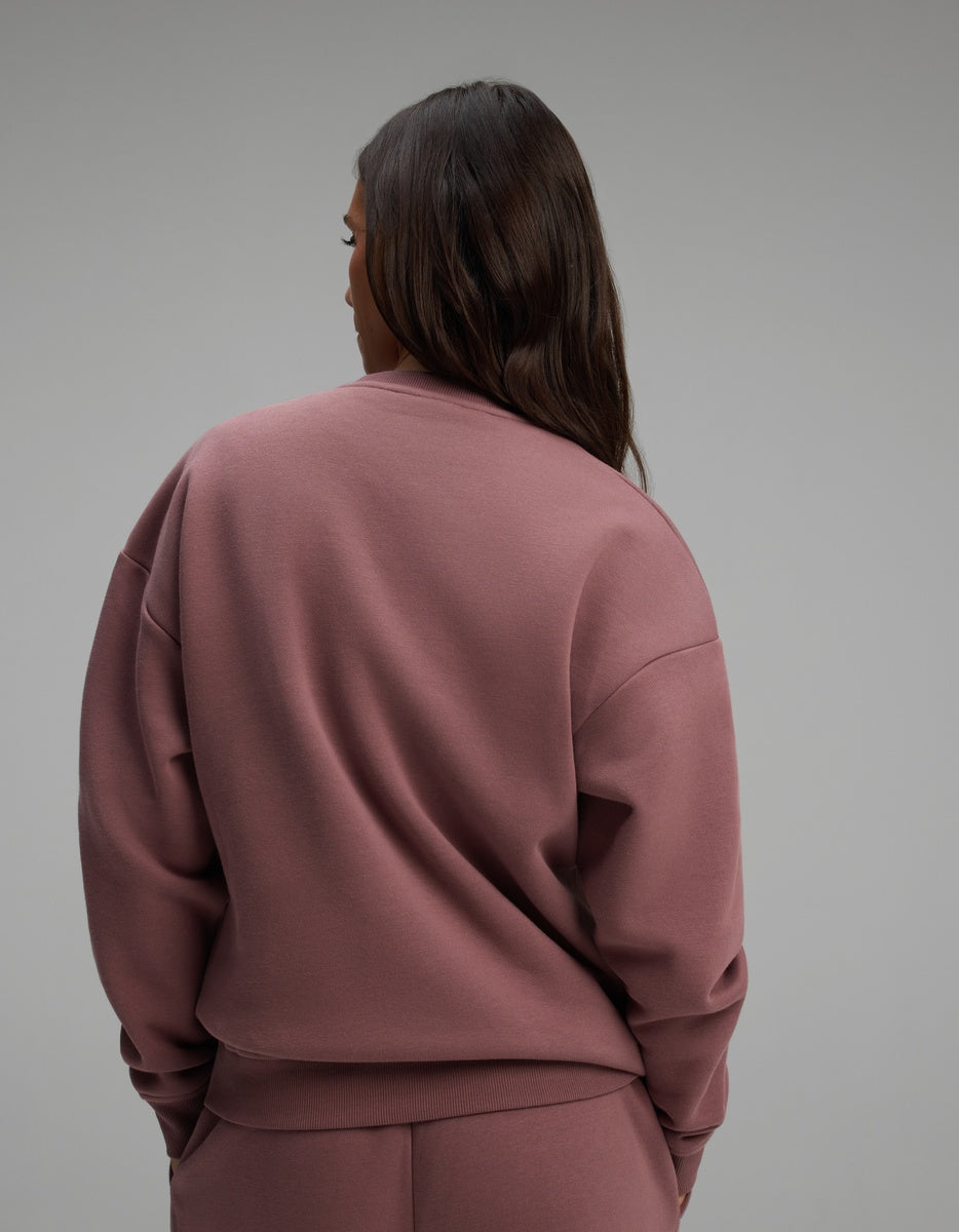 A person seen from behind, wearing a dusty rose long-sleeved Cozy Earth Women’s CityScape Crewneck.