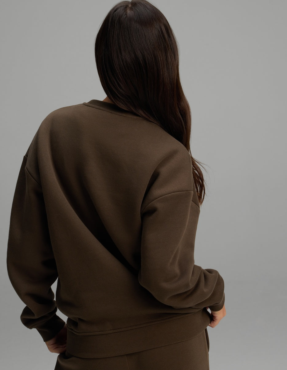A person viewed from behind wearing a brown Cozy Earth Women’s CityScape Crewneck with dropped shoulders.