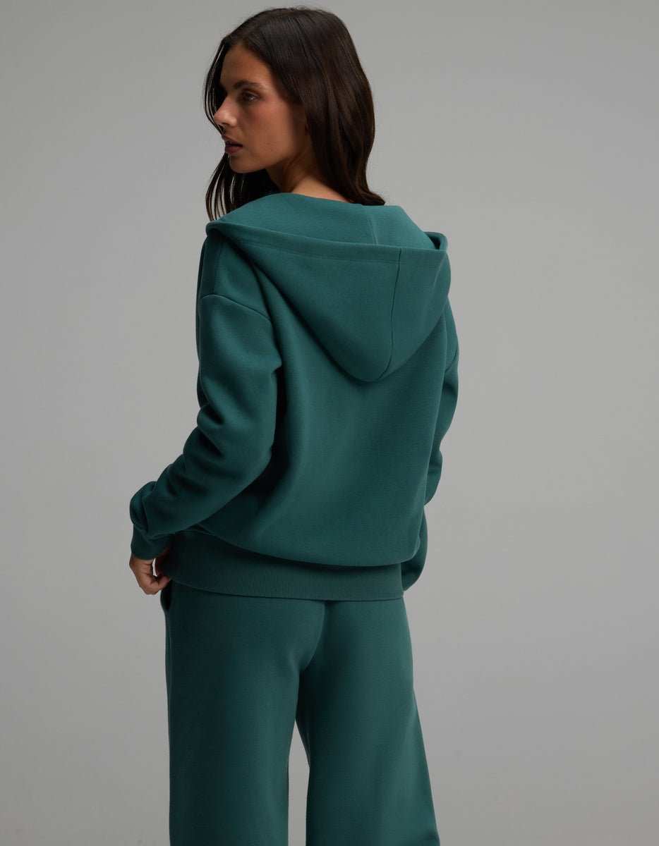 A person from behind wearing a teal Cozy Earth Women’s CityScape Full-Zip Hoodie with matching pants.