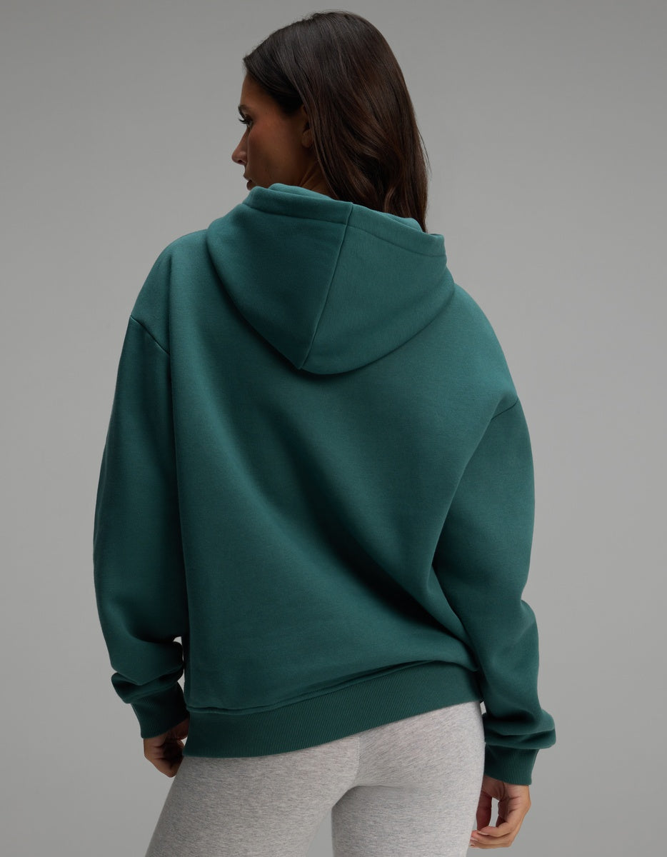 A person seen from the back wearing a dark teal Women’s CityScape Hoodie.
