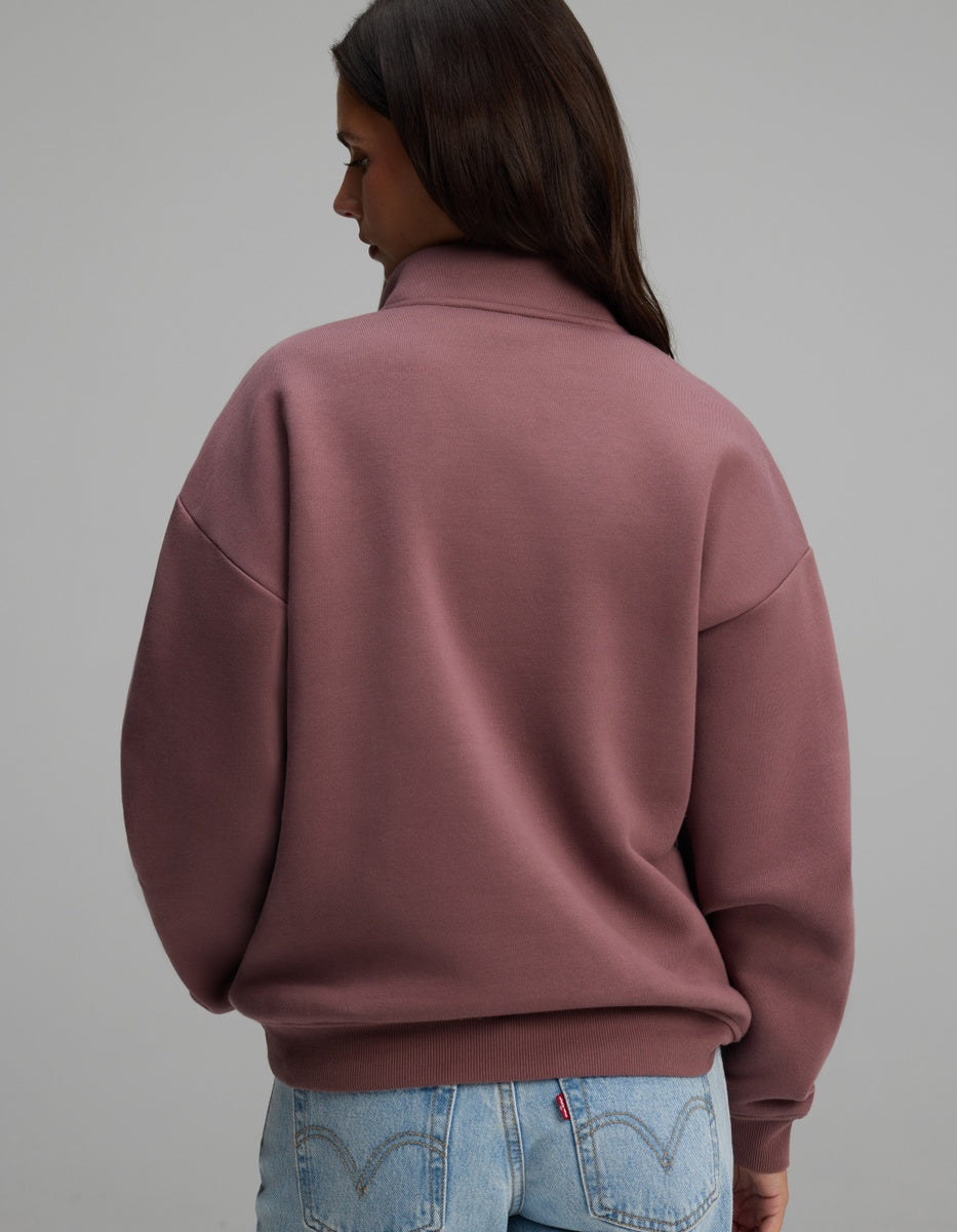 A woman seen from behind wearing a mauve Women’s CityScape Quarter Zip with dropped shoulders and ribbed cuffs.