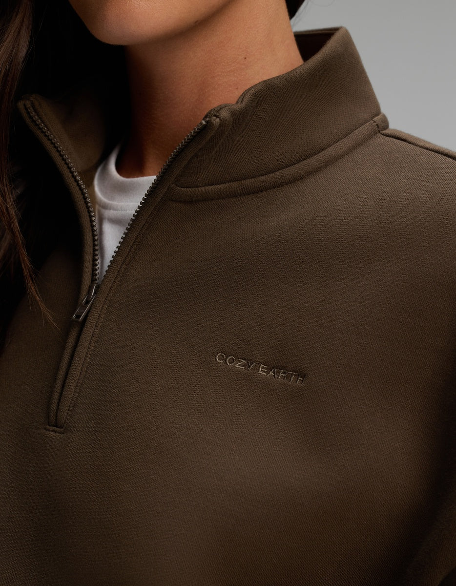 Olive green Women’s CityScape Quarter Zip with a high collar, worn over a white shirt.