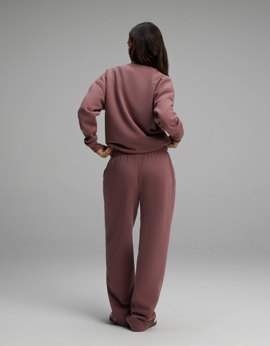 Rear view of a person wearing a mauve Cozy Earth Women’s Cityscape Crewneck & Wide Leg Pant Set consisting of a crewneck sweatshirt and matching wide-leg lounge pants.