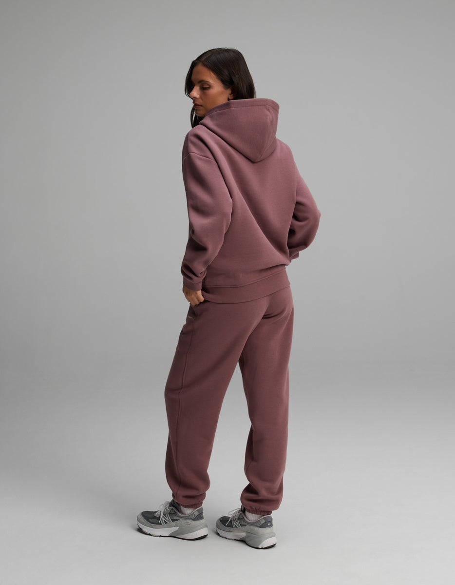 A woman wearing a matching mauve Cozy Earth Women’s Cityscape Hoodie & Sweatpant Set.