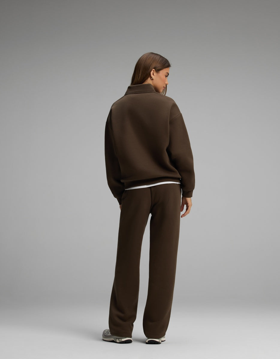A person seen from behind wearing the dark brown Cozy Earth Women’s Cityscape Quarter Zip & Wide Leg Pant Set, featuring a quarter-zip sweatshirt and matching wide-leg pants.