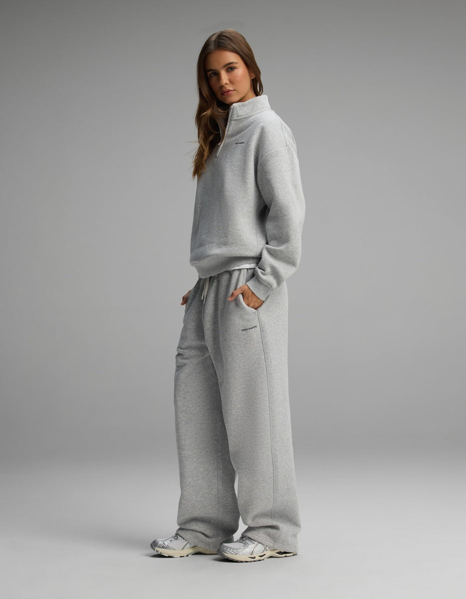 A woman wearing a light gray Women’s Cityscape Quarter Zip & Wide Leg Pant Set, standing with her hands in her pockets.
