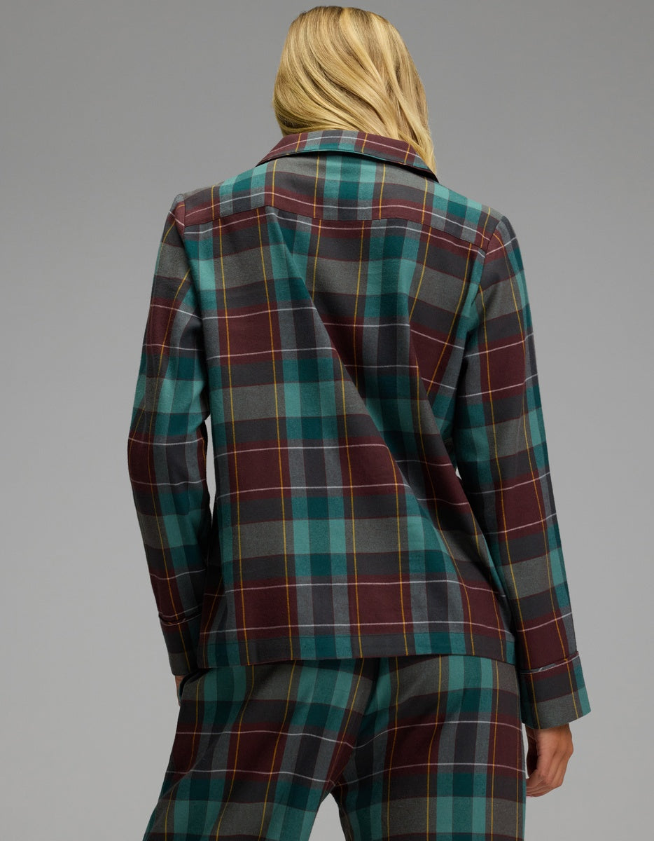 A person seen from behind wears the Women’s Farmhouse Long Sleeve Pajama Top and matching pants in a teal, maroon, and yellow plaid pattern.
