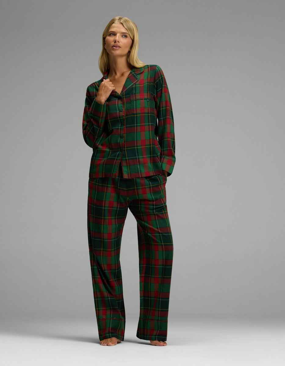 A person wearing a red and green plaid Cozy Earth Women’s Farmhouse Long Sleeve Pajama Top and matching trousers.