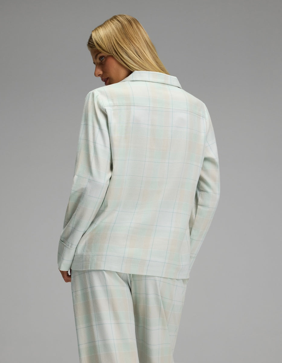 Back view of a person wearing a light blue and white plaid Cozy Earth Women’s Farmhouse Long Sleeve Pajama Top with a collared neckline and long sleeves.