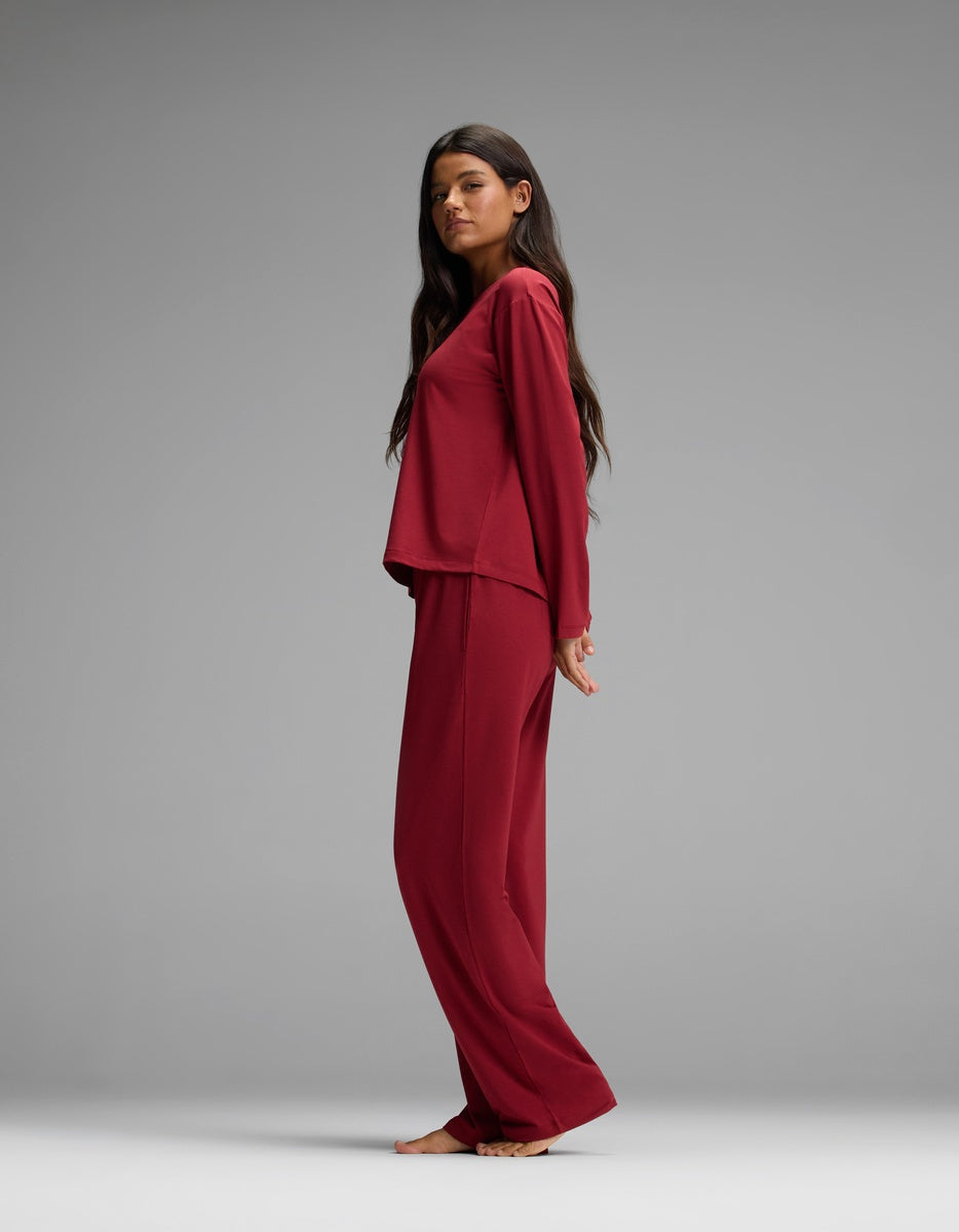 A woman wearing a dark red Women’s First Layer Long Sleeve Sleep Tee & Pajama Pant Set.
