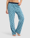 Model is wearing Cozy Earth's Women's First Layer Pajama Pant in light blue with dark blue polka dots and a dark elastic waistband, shown barefoot on a white background.|Color:Blueberries

