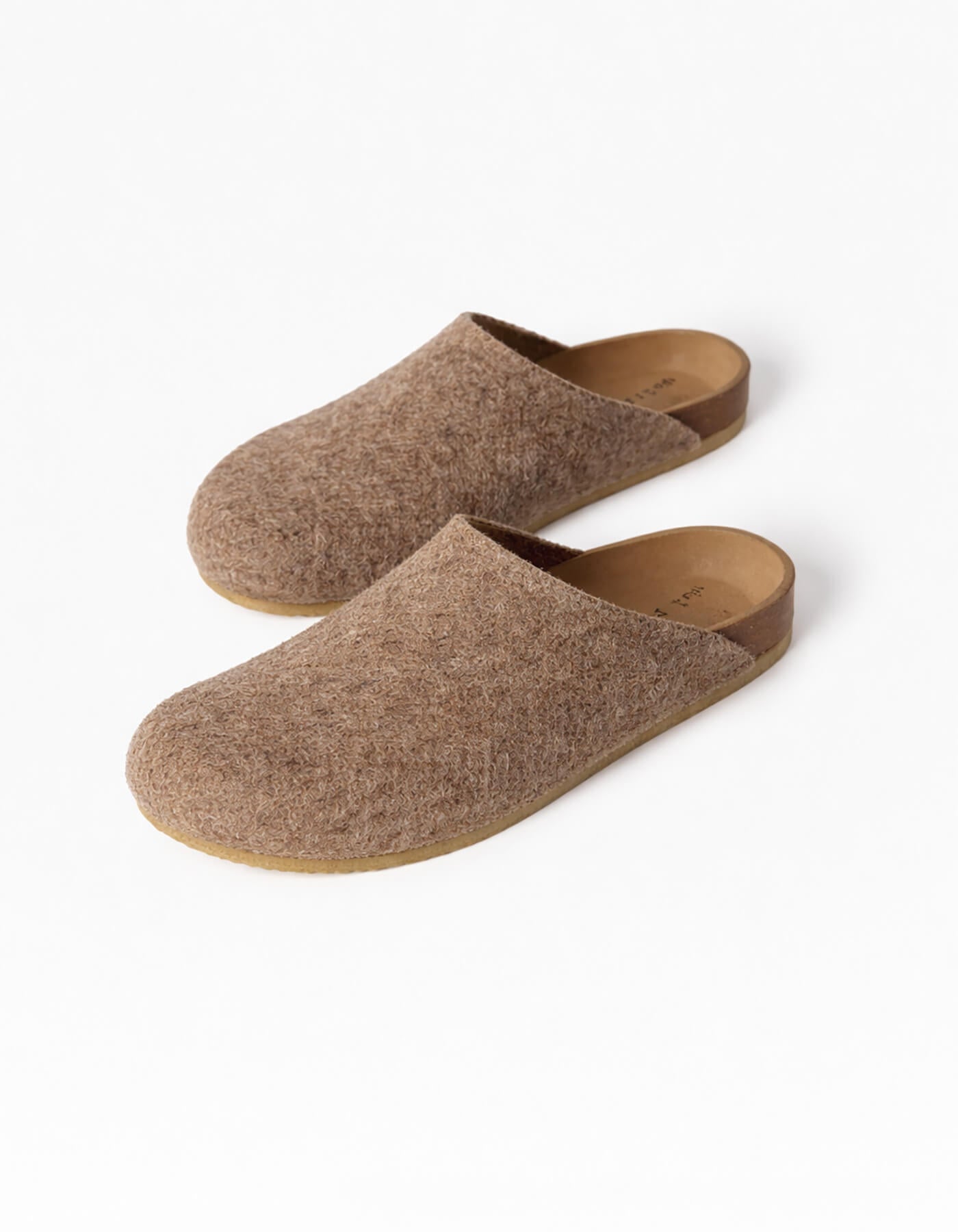 The Lakehouse Clog by Cozy Earth are brown woolen slip-on slippers with a cork sole, viewed from above. They feature a minimalist design perfect for indoor use against a light grey background. |Color:Chestnut