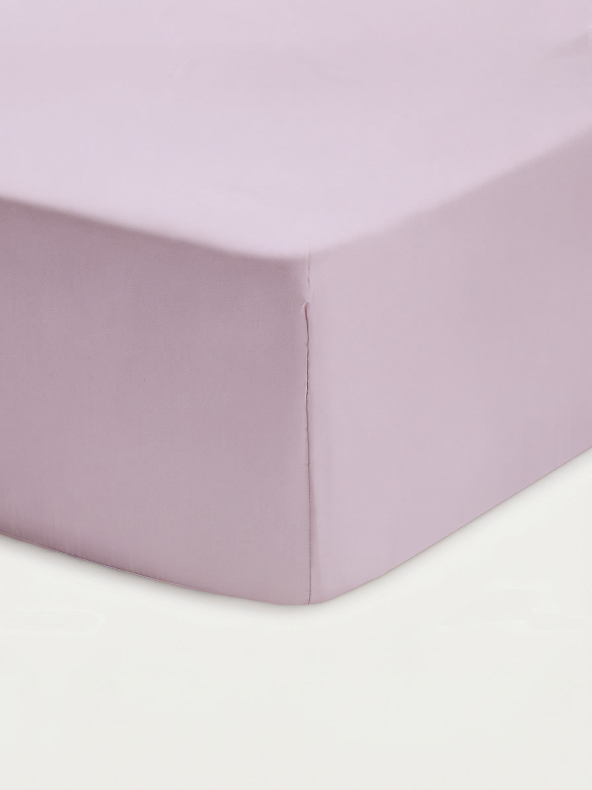 Close-up of the Cozy Earth Bamboo Fitted Sheet in a light lavender hue, snugly covering the corner of a mattress with a smooth, neatly tailored finish against a white background.