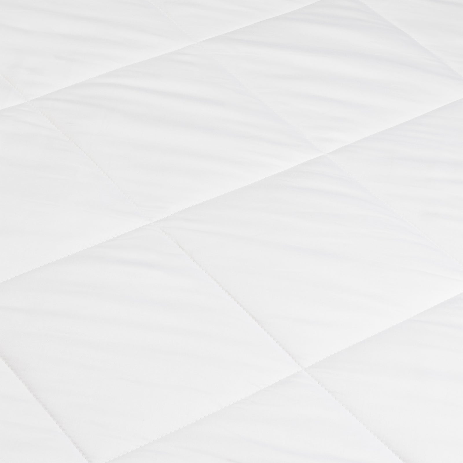 A close-up of the Cozy Earth Bamboo Viscose Comforter shows its smooth, soft white quilted fabric with a diamond pattern formed by intersecting stitched lines.