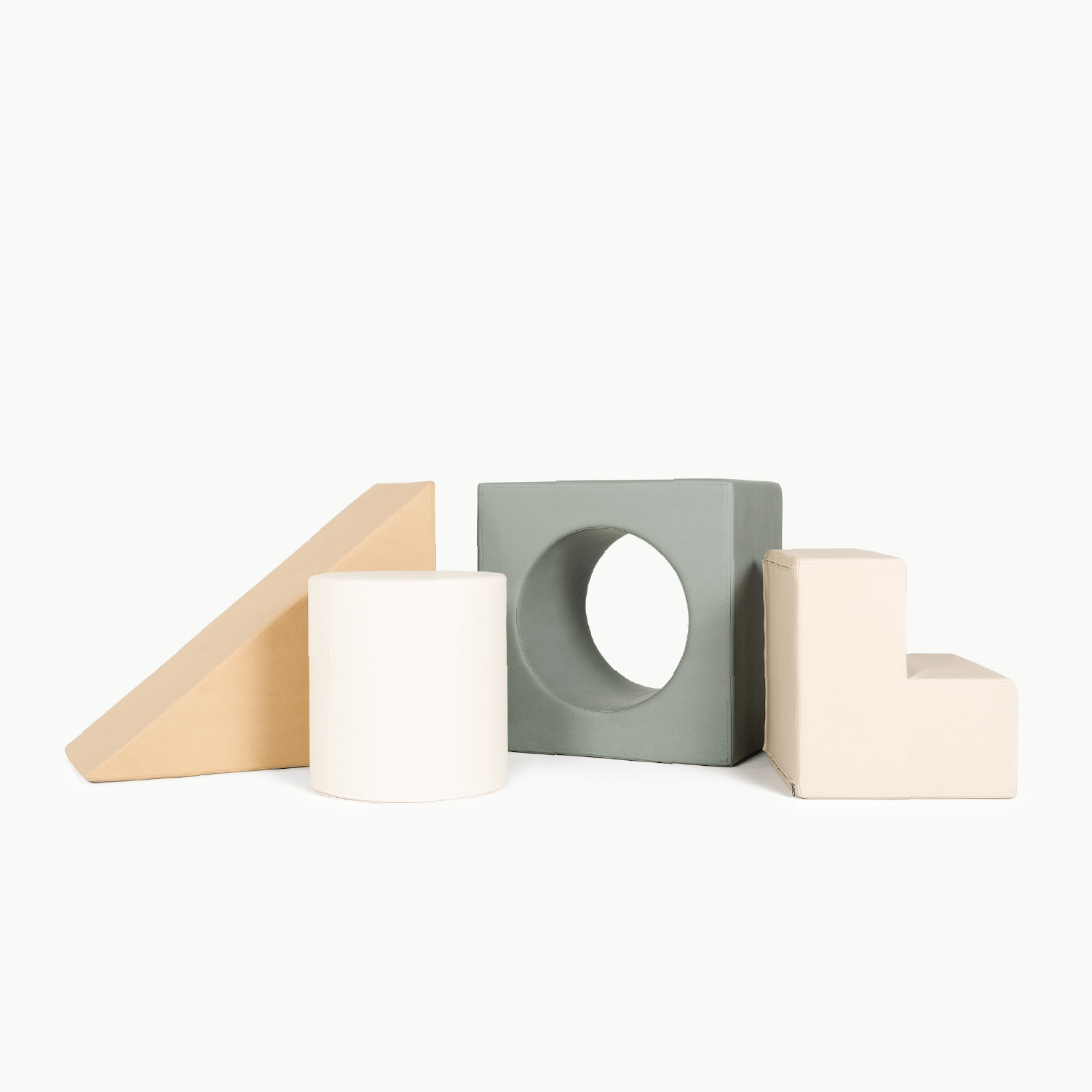 The Gathre Wholesale Block Playset features four foam blocks in neutral tones: a beige wedge, white cylinder, green square with a circular hole, and cream L-shape, all displayed side by side against a white background.