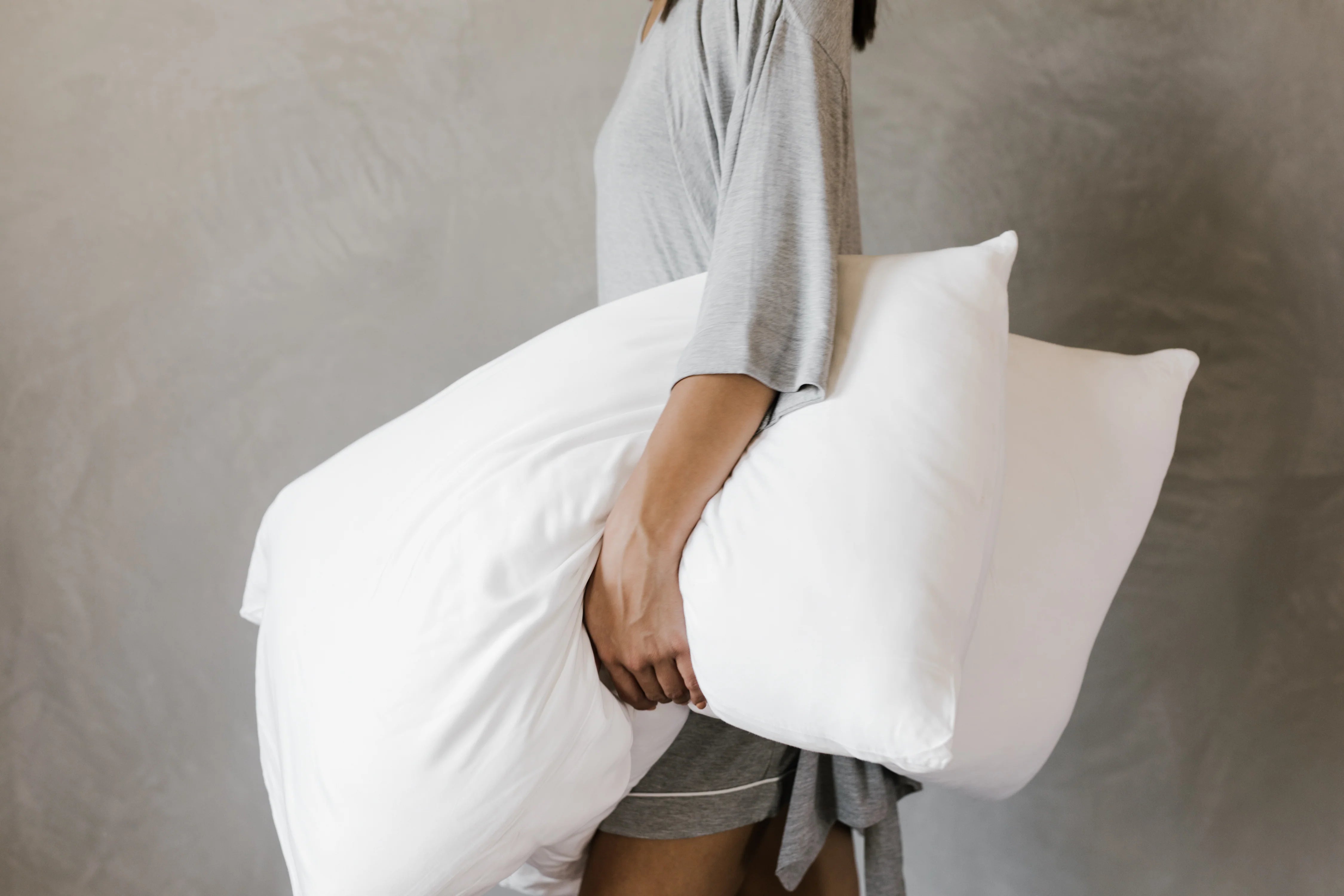 A women holds a pair of Cozy Earth pillows.