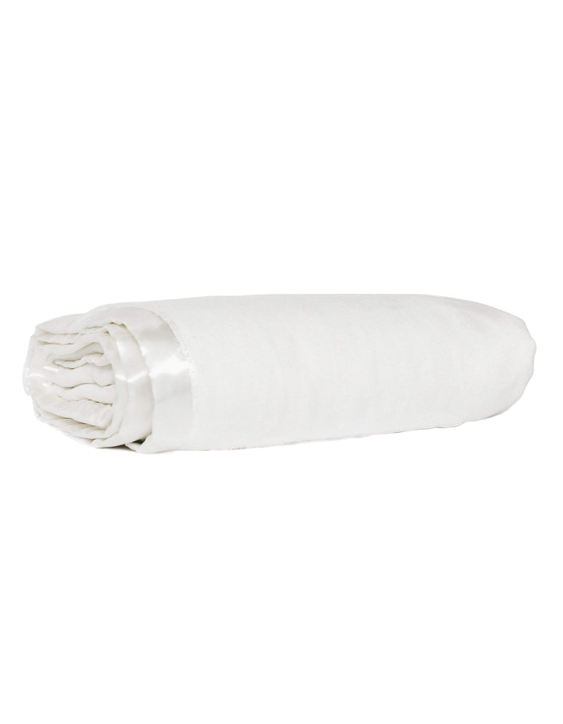 The Cozy Earth Baby Blanket by Cozy Earth, featuring a white color and satin trim, is neatly rolled up and displayed on a white background.